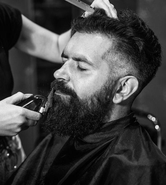 Barbearia masculino na moda corte de cabelo perfeito com lâmina de barbeiro mestre de barbeiro corta cabelo maduro hipster com barba no cabeleireiro brutal hipster com bigode fazendo novo penteado Cabelo como fogo