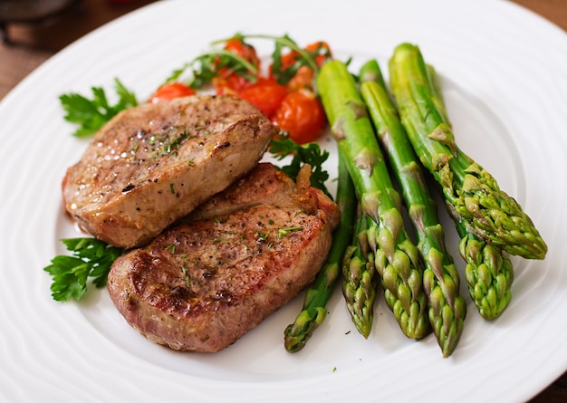 Barbecue gegrilltes Rindersteakfleisch mit Spargel und Tomaten.