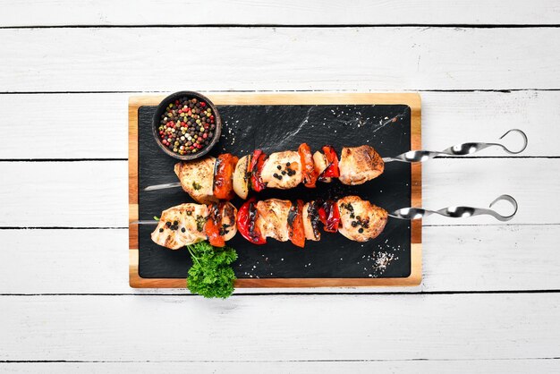 Barbecue Hähnchen am Spieß mit Zwiebeln und Tomaten Barbecue Draufsicht Freier Platz für Ihren Text Rustikaler Stil