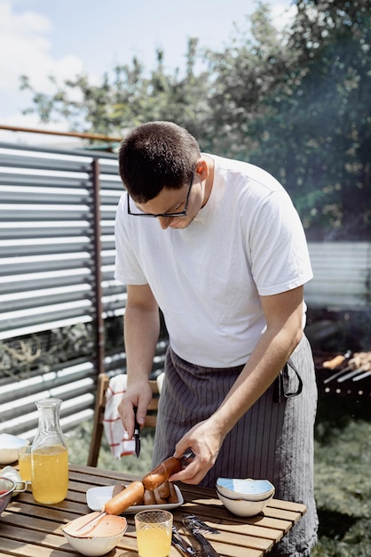 Foto barbecue no quintal mãos do homem grelhando kebab e vegetais em espetos de metal