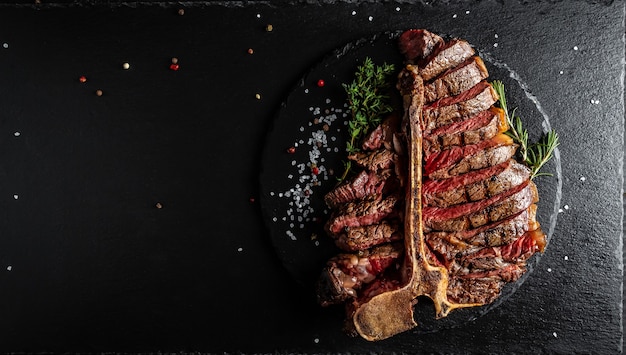 Barbecue trocken gealtertes Wagyu Porterhouse Steak, gegrilltes mittelrares Rindersteak mit Gewürzen, serviert auf Schieferbrett