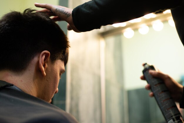 Barbeiro ajustando o cabelo de um homem no salão