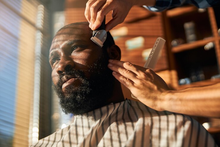 Foto barbeiro aparando a barba do cliente na barbearia