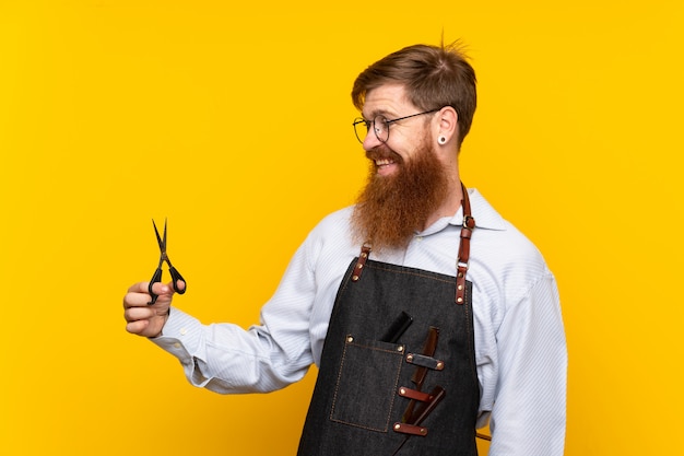 Barbeiro com barba longa em um avental com expressão feliz