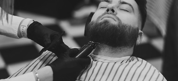 Barbeiro cortando barba de cliente masculino