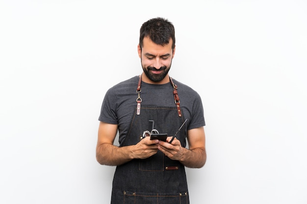 Barbeiro de avental, enviando uma mensagem com o celular