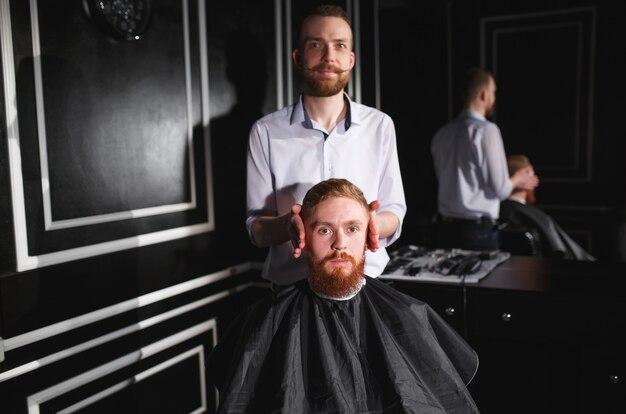 Barbeiro de visita do homem confiável na barbearia.