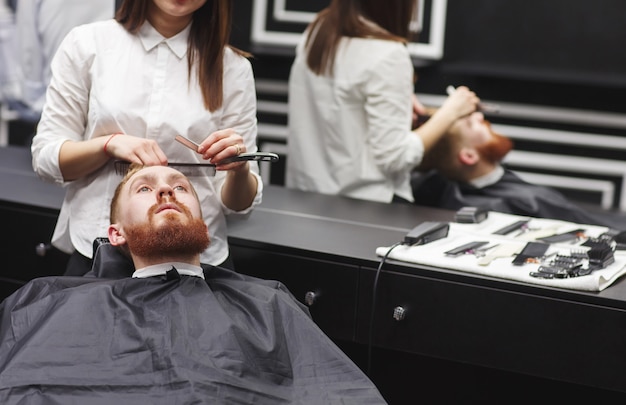 Barbeiro de visita do homem confiável na barbearia.