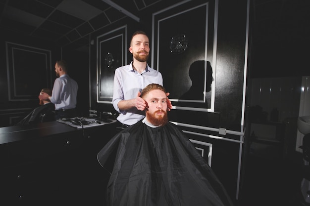 Barbeiro de visita do homem confiável na barbearia.