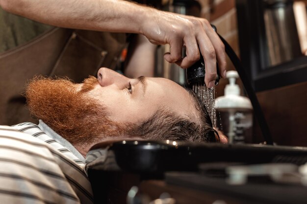 Barbeiro e homem barbudo na barbearia