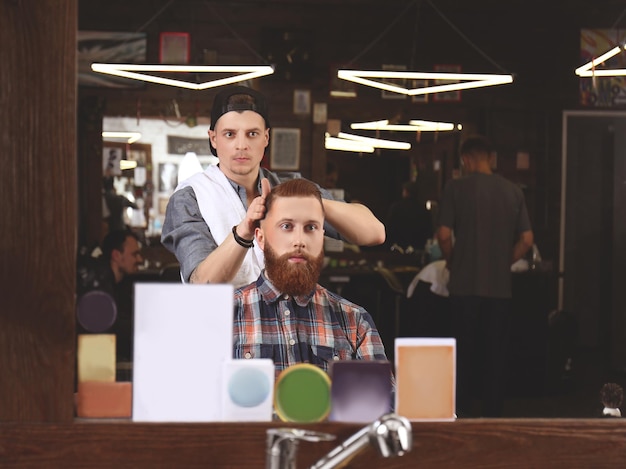 Barbeiro fazendo penteado masculino moderno