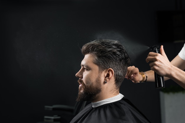 Barbeiro fazendo penteado para hipster barbudo confiante. Publicidade para barbearia e salão de beleza masculino.