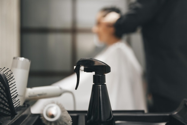 Barbeiro profissional em um fundo desfocado com um cabeleireiro fazendo um corte de cabelo para um cliente