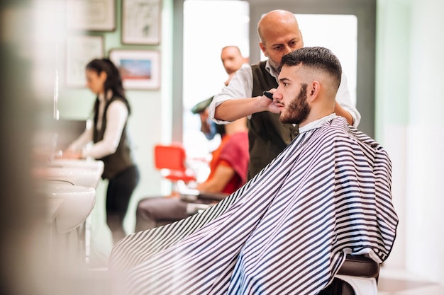 Barbeiro profissional fazendo corte de cabelo para cliente