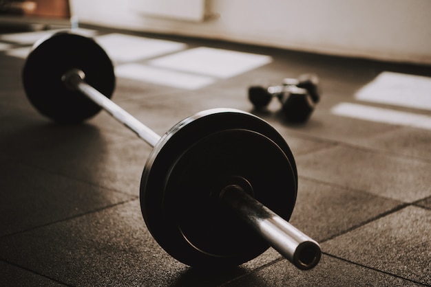 Barbell and Dumbbells está tendido en el suelo en el gimnasio