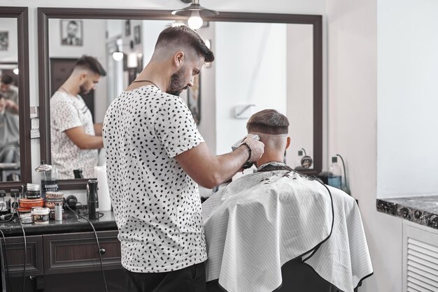 Barber corta o cabelo da cliente. Corte de cabelo masculino na barbearia.