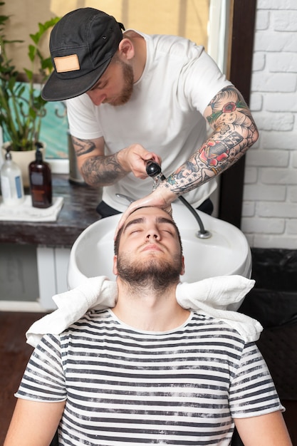 Barber enxugando a cabeça de seu cliente com uma toalha