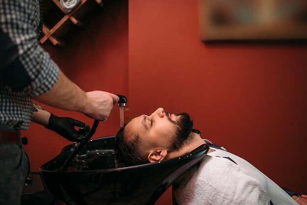 Barber wäscht die Haare eines Kunden