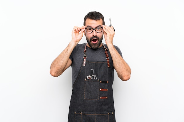 Barbero en un delantal con gafas y sorprendido