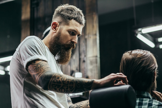 barbero de pie junto al hombre y peinándose