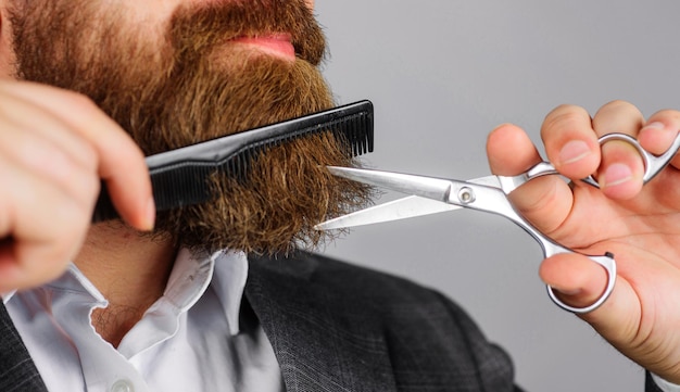 Barbershop bärtiger mann mit schere und kamm friseurwerkzeuge professioneller bartpflegesalon für männer