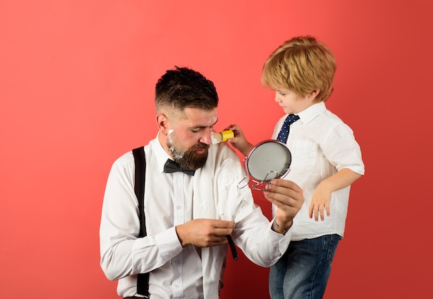 Barbershop kleiner Junge hält Friseurschere Friseur mit Rasiermesser zum Rasieren Friseursalon