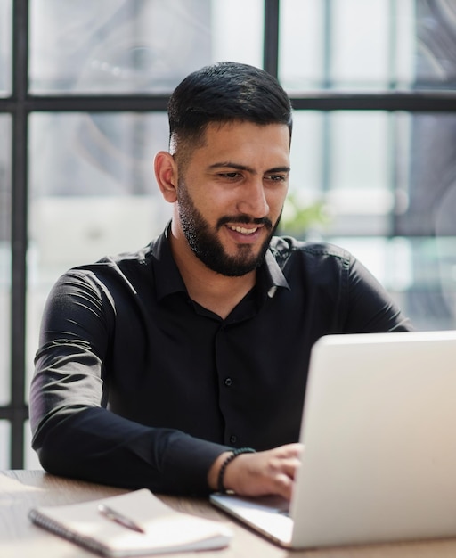 Barbudo jovem empresário trabalhando no escritório moderno Homem consultor pensando olhando no computador monitor