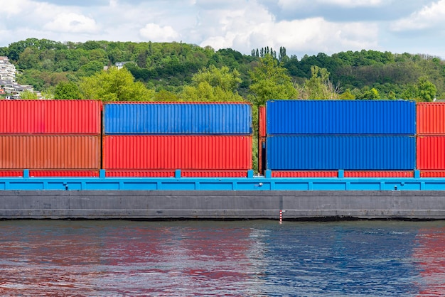 Foto una barcaza que transporta muchos contenedores en el rin en alemania occidental árboles y edificios en la parte trasera