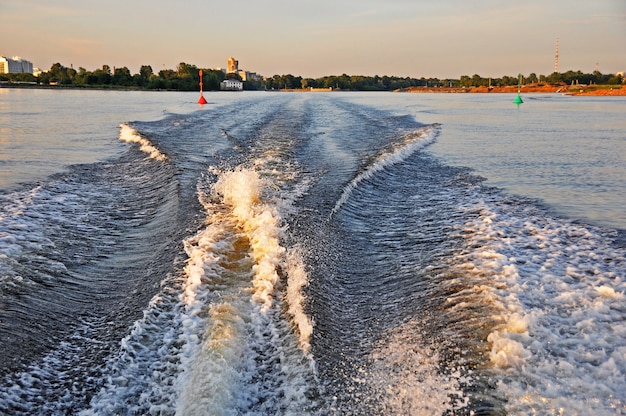 Barco a motor branco voando rápido nas ondas