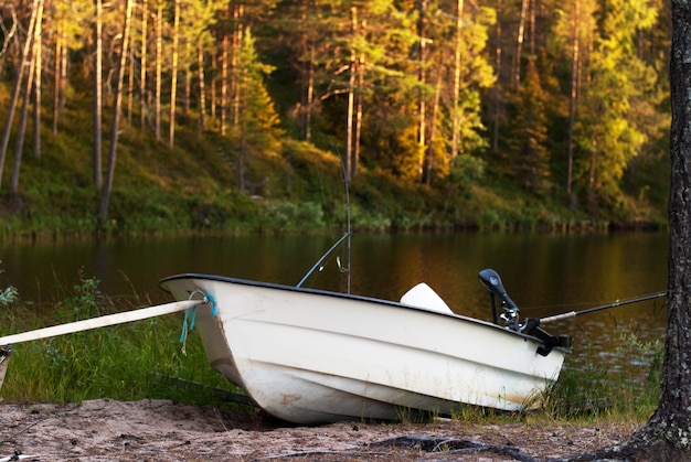 Barco a motor com varas de pescar na margem do lago