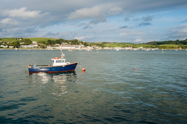 Barco a motor de pesca azul amarrado no estuário em Appledore Devon