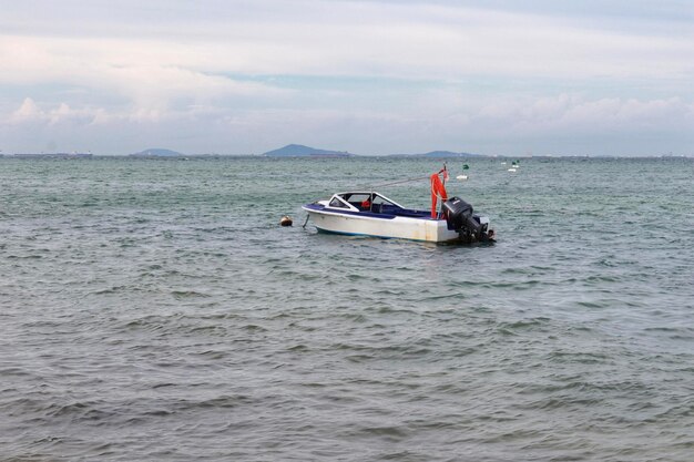 Barco a motor de tinta branca e tinta azul por dentro, sem ninguém flutuando em algum lugar no mar