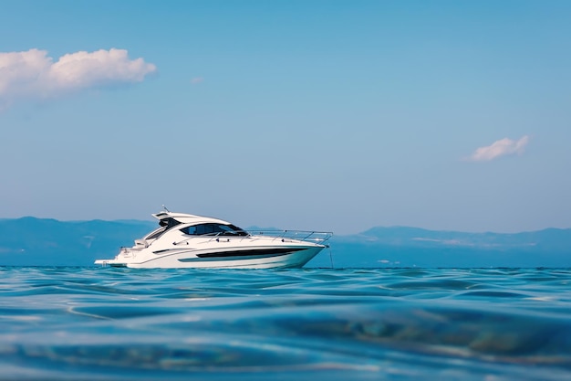 Foto barco a motor flutuando em águas cristalinas azul-turquesa