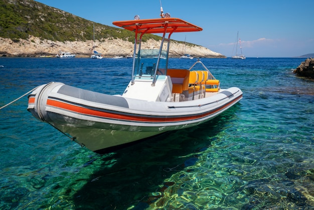 Barco a motor na água clara do oceano em Hvar, Croácia.