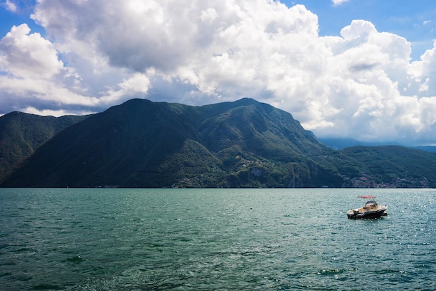 Barco a motor no aterro do resort de luxo em Lugano nas montanhas do Lago Lugano e Alpes no cantão de Ticino, Suíça.