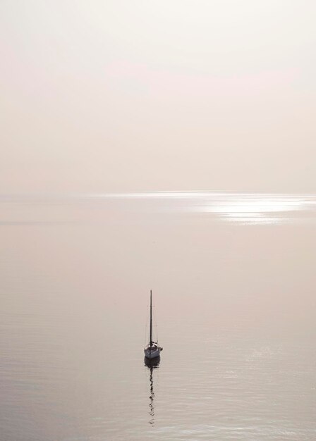 Foto barco a navegar na sicília ao pôr-do-sol