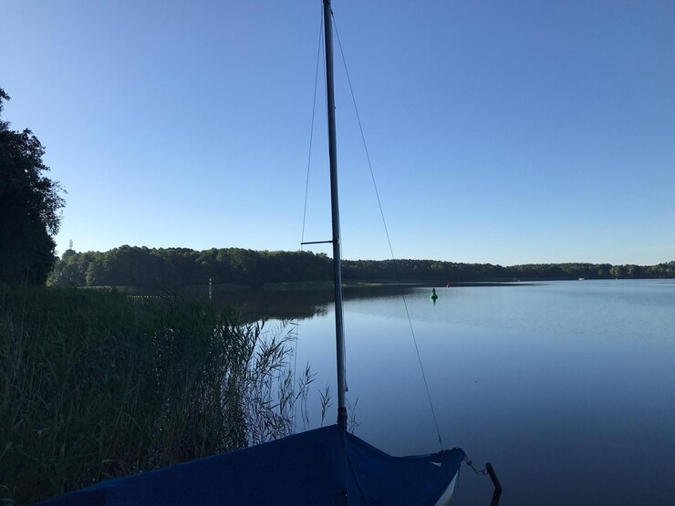 Foto barco a navegar no lago contra um céu azul claro
