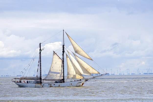 Foto barco a vela a navegar no mar contra o céu