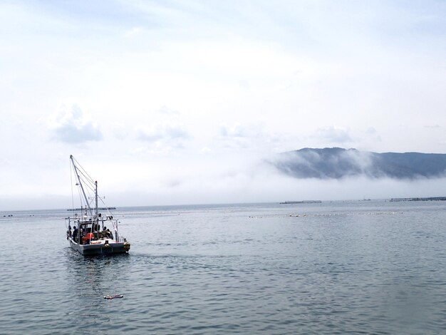 Foto barco a vela a navegar no mar contra o céu