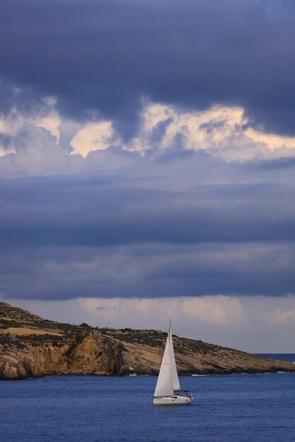 Foto barco a vela a navegar no mar contra o céu