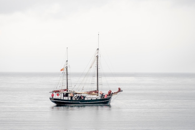 Foto barco a vela a navegar no mar contra o céu