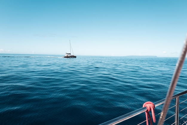Barco a vela a navegar no mar contra um céu azul claro