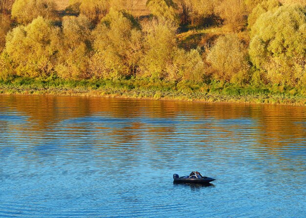 Barco à vela no fundo do rio de outono