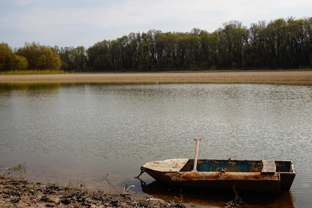 Barco abandonado ancorado na margem do lago