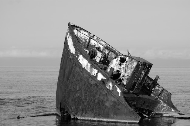 Barco abandonado en la playa contra el cielo