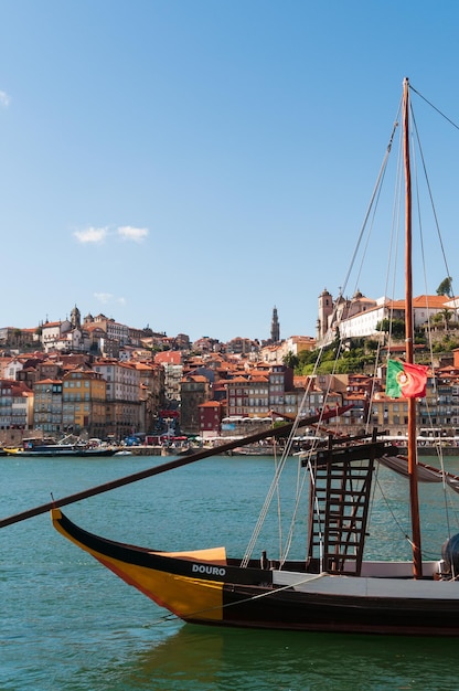 Un barco en el agua con la ciudad de Oporto al fondo