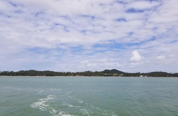 Un barco en el agua con las montañas al fondo.