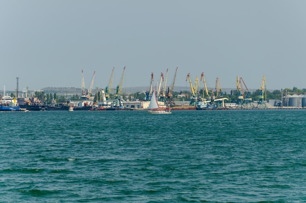 Un barco en el agua con un velero blanco en primer plano