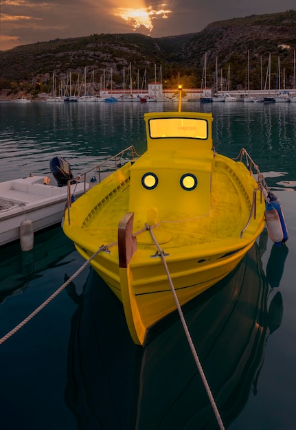 Foto un barco amarillo se encuentra en el puerto de la ciudad de methana en el peloponeso en grecia al atardecer