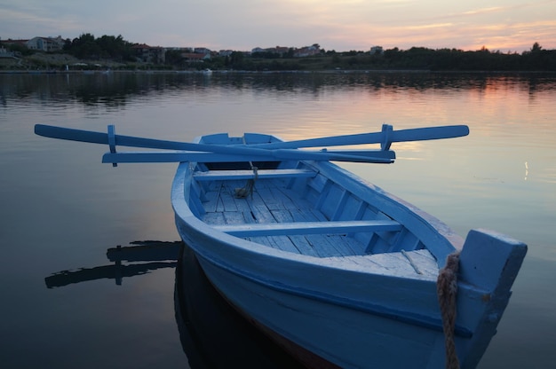 Barco amarrado en el lago contra el cielo durante la puesta de sol